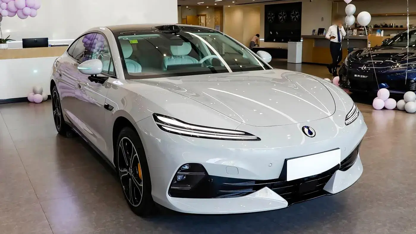 Denza Z9S front three-quarter at a showroom, with a Z9GT parked beside it