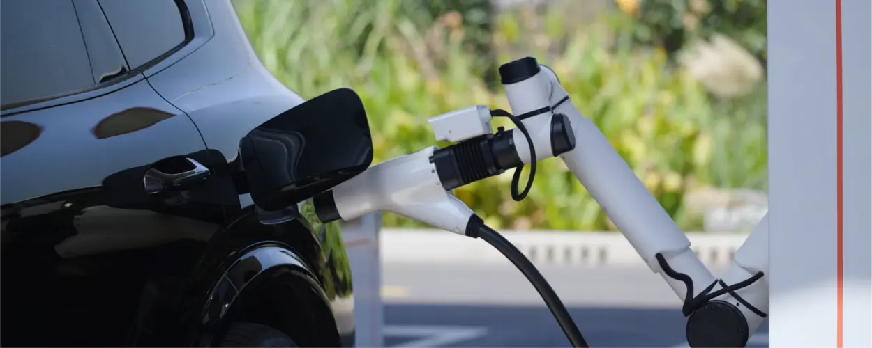 Liquid-cooled charging connector plugged into a black electric car