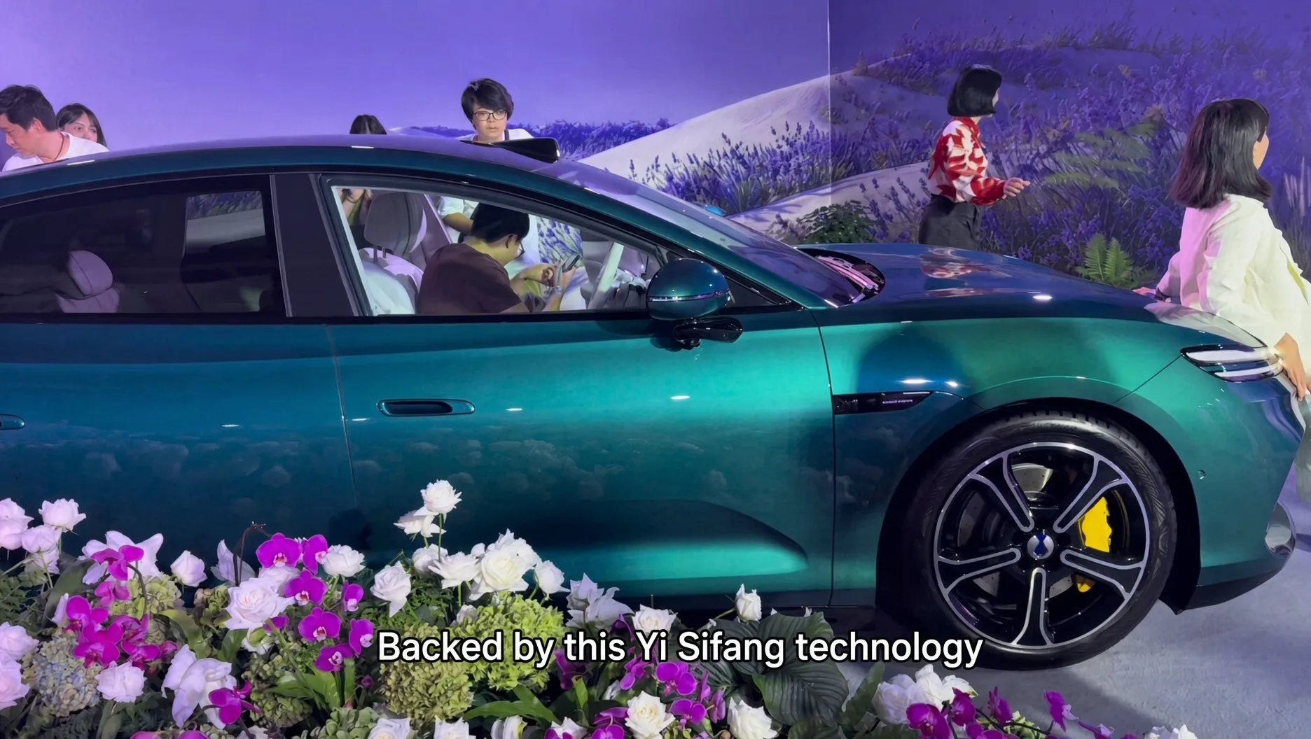 Denza Z9S show car in green on the stage at the launch event, with a flower display in front