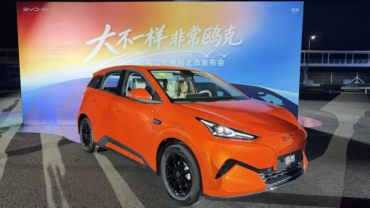 Orange second-generation BYD Seagull beneath the launch slogan backdrop